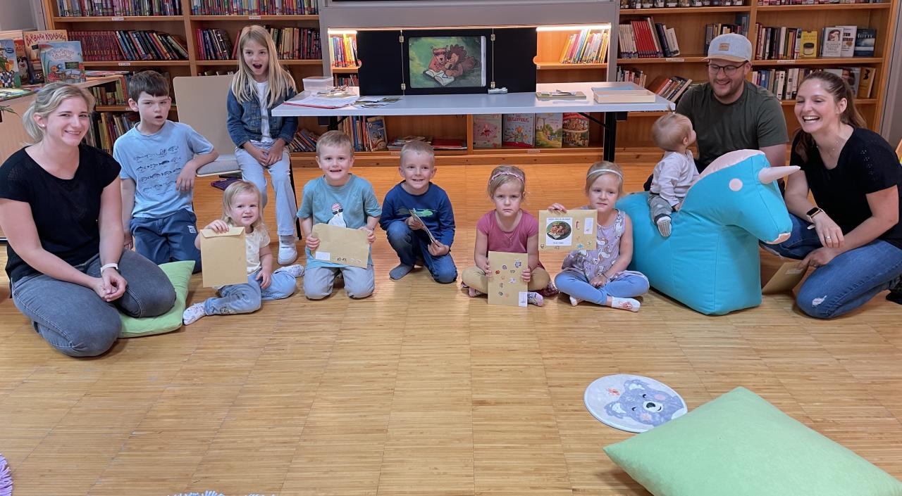 Kinder in der Bücherei am Boden sitzend