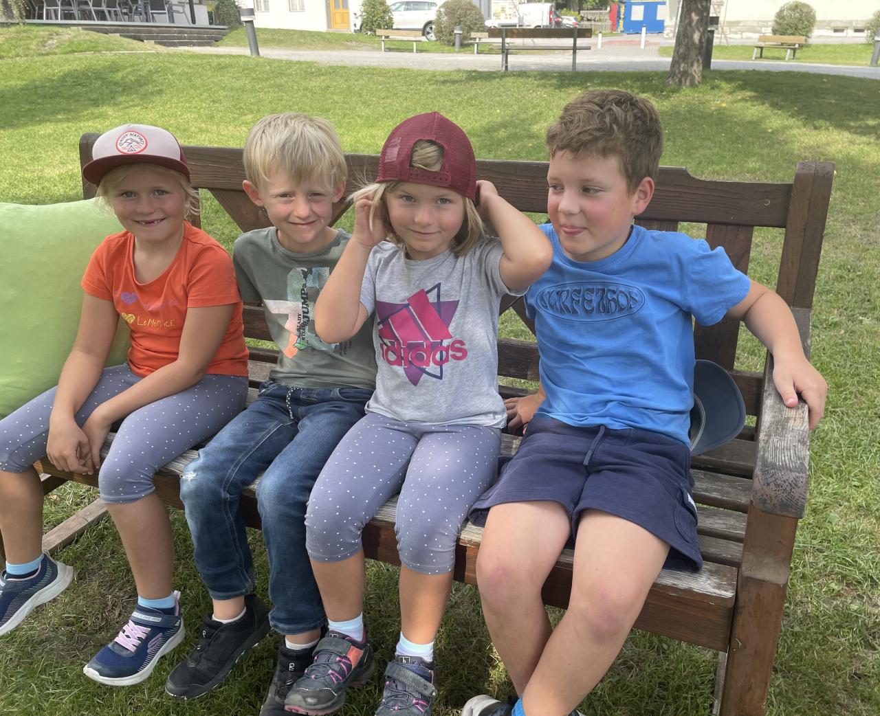 Kinder auf einer Bank im Freien sitzend