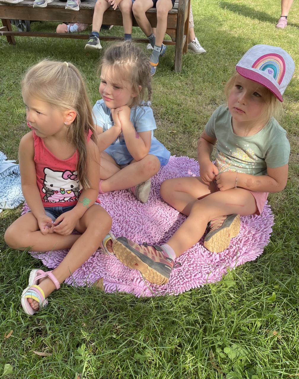 Drei Mädchen auf einer Decke sitzend