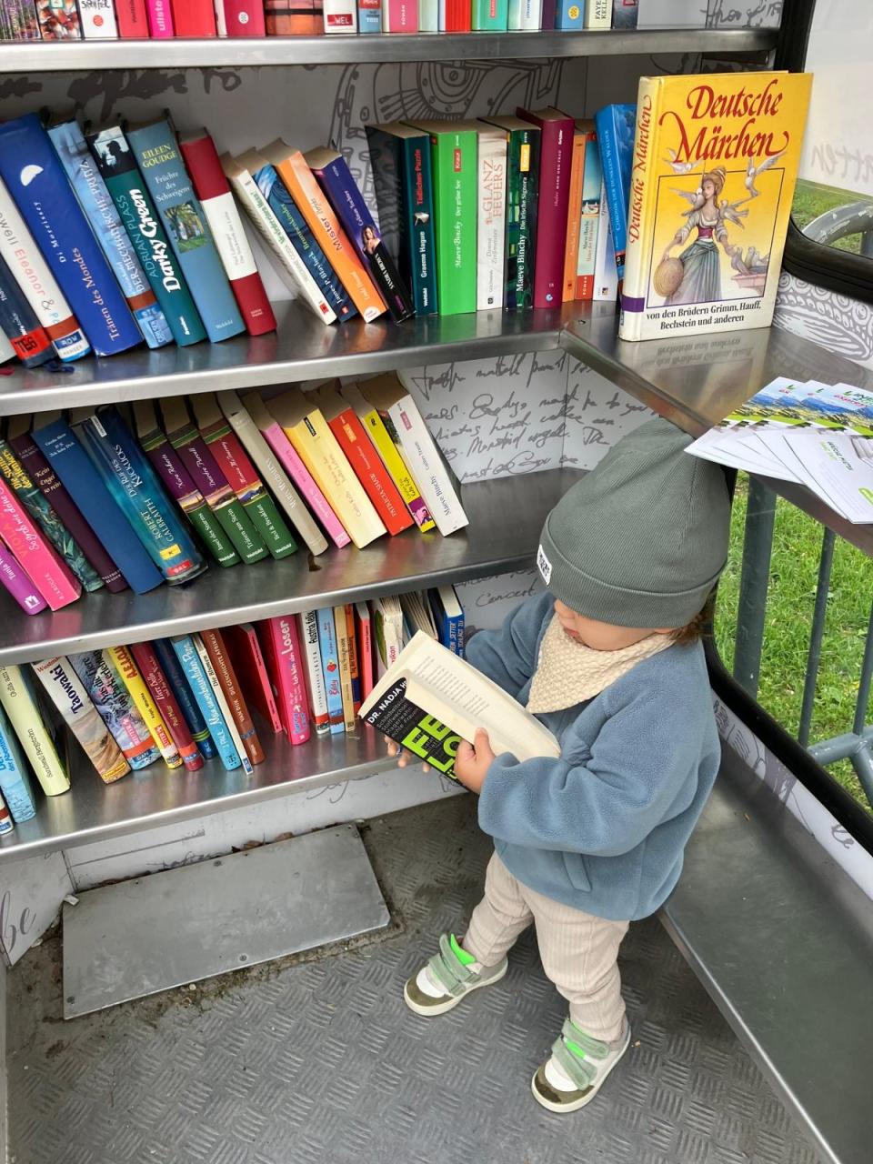 Kleines Kind in der Bücherzelle